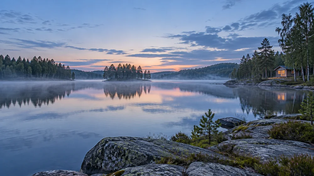 Usva nousee suomalaisen järven yllä mäntyjen ja rantakallioiden keskellä.